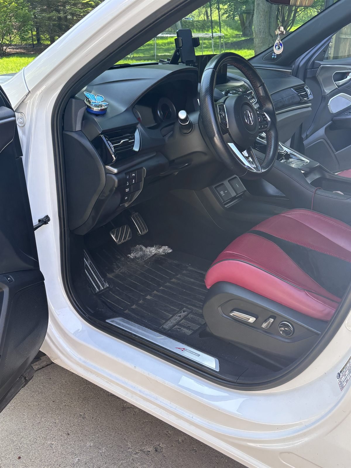 Before detailing: dirty passenger-side floor and door sill of a white car