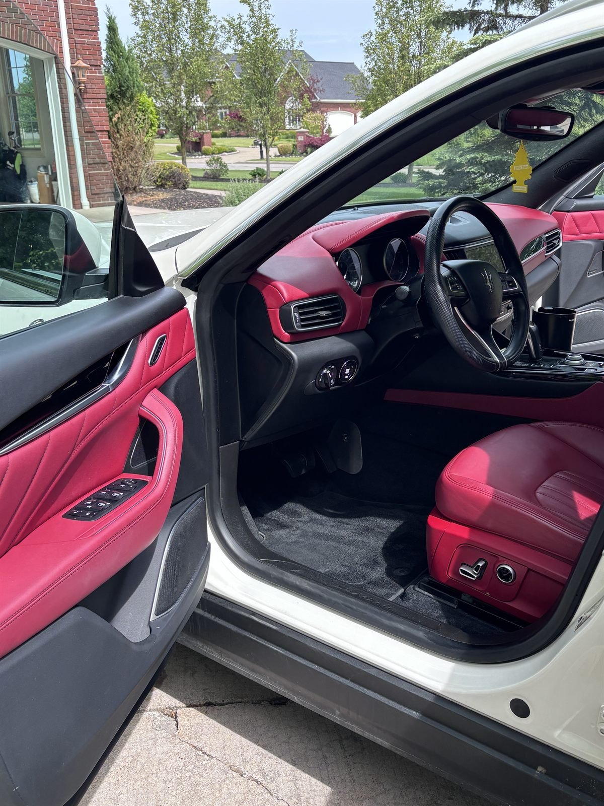 Detailed driver-side interior with red leather seat and door panel